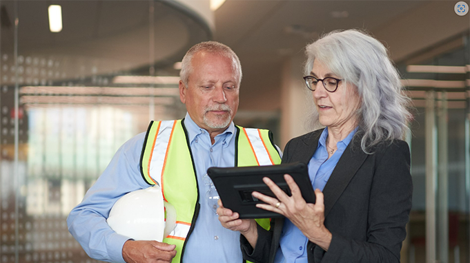 Man and woman standing looking at a tablet