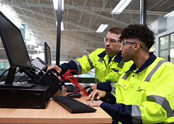 two men working and looking at a computer